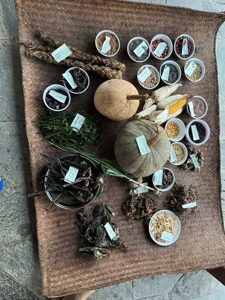 Flat-lay of labelled foraged Nepali ingredients on a woven mat