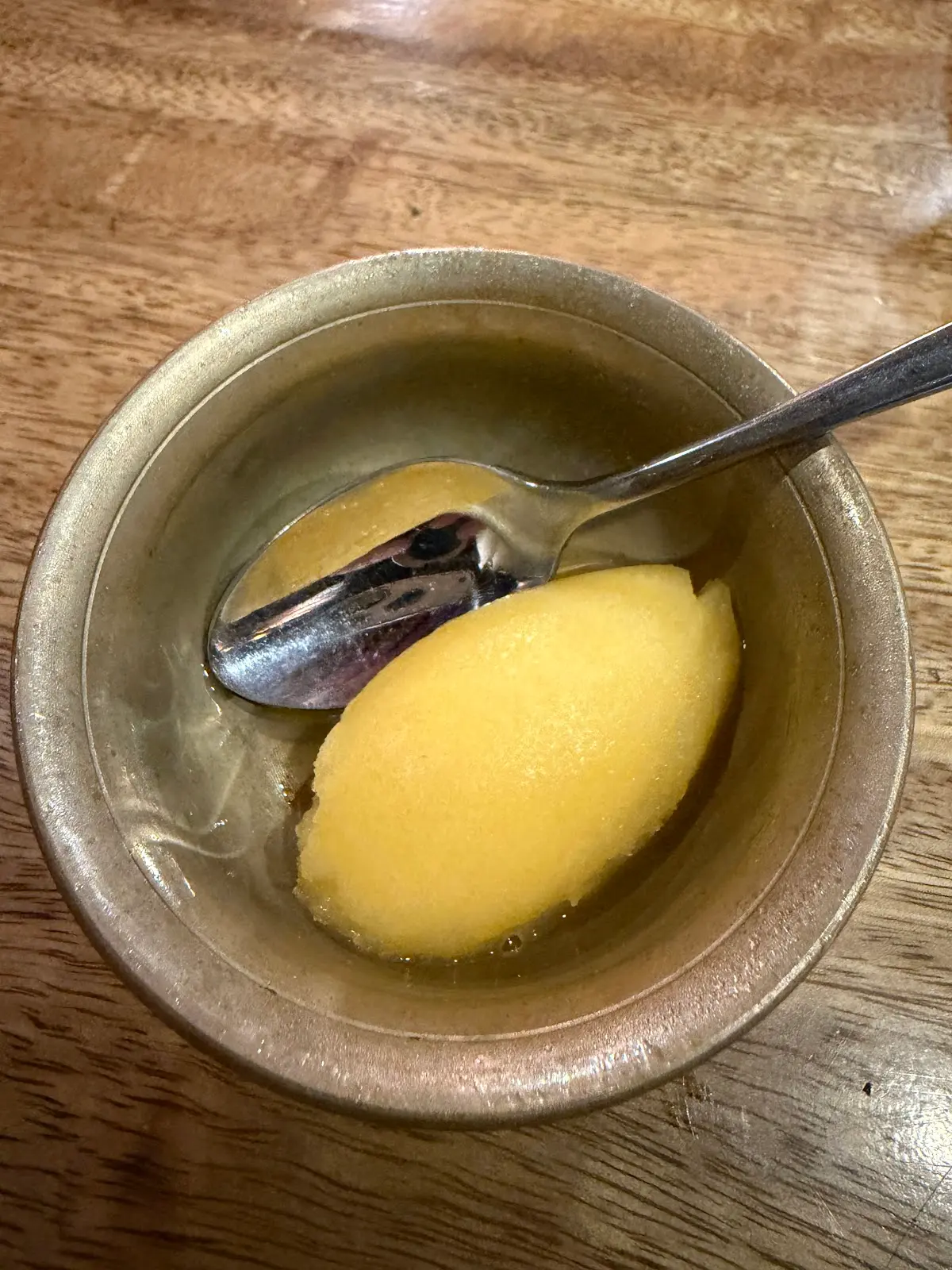 Bright citrus sorbet quenelle in a glazed clay bowl