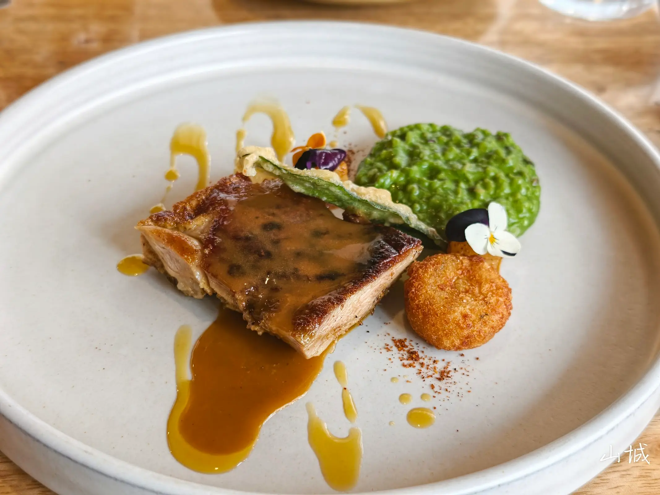 Wood-fire seared meat with green pea purée and edible flowers